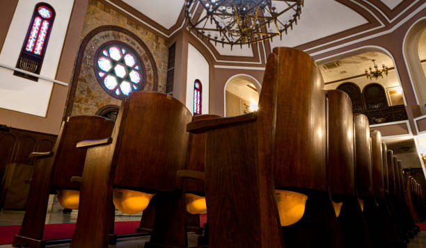 синагога неве-шалом. каски расположены под каждым стулом. стамбул, турция - torah ark стоковые фото и изображения