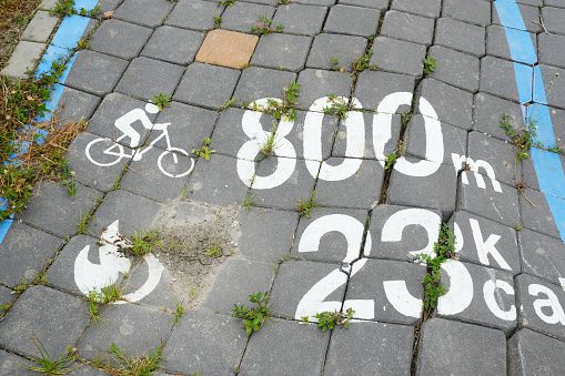 A picture of bicycle sign with distance and calorie burn marking on the pavement.