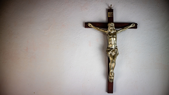 a cross hung on a white wall