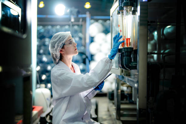 istock scientist worker checking the quality of Reverse osmosis machine system at the industrial factory. Female worker recording data at the control panel with measure pressure for recycle portable plant. 1691432993