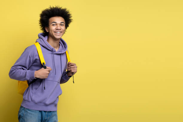 istock Smiling university student with backpack isolated on yellow background, copy space. Education 1691437222