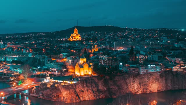 Tbilisi, Georgia. day to night time lapse timelapse. Top View Of Famous Landmarks In spring sunset Evening dusk night. Georgian Capital Skyline Cityscape. Justice House, Bridge Of Peace, Concert Hall, Rike Park And Presidential Palace