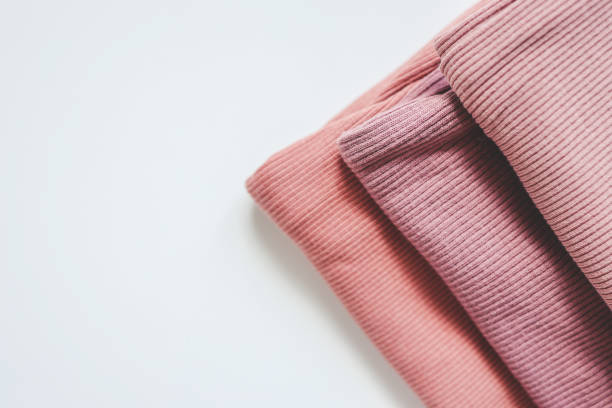 istock Stack of pink baby clothes on white background 1691482893