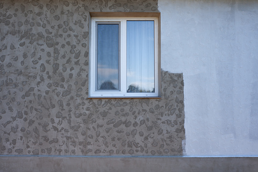 Part of the wall painted with white paint, repair of the facade of the house, Texture of the facade and window of the house