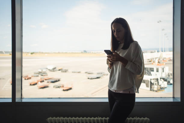 istock Woman using smartphone at the airport 1691528434
