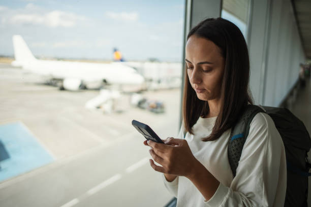 istock Woman using smartphone at the airport 1691528457