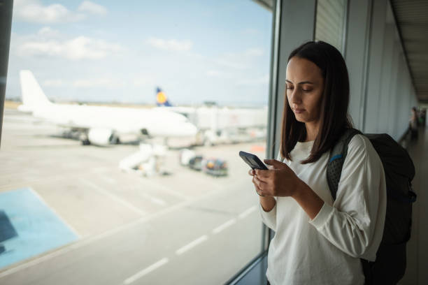 istock Woman using smartphone at the airport 1691528963
