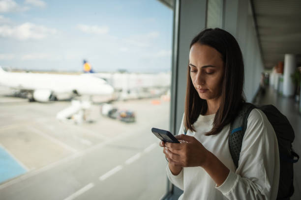 istock Woman using smartphone at the airport 1691528964