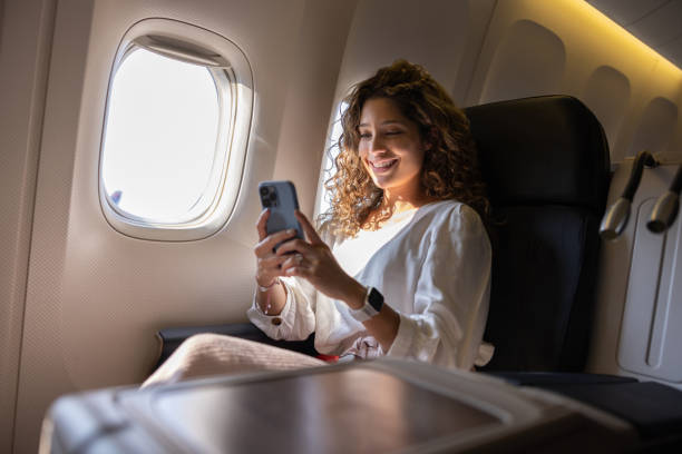 istock Woman using her cell phone while traveling by airplane 1691534152