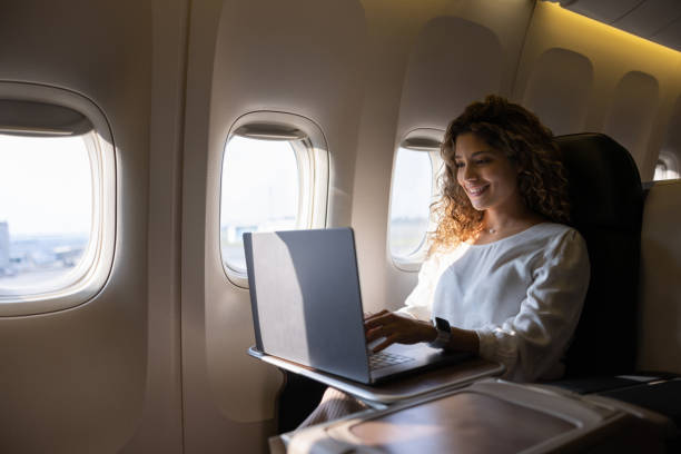 istock Airplane passenger working on her laptop while traveling 1691534158