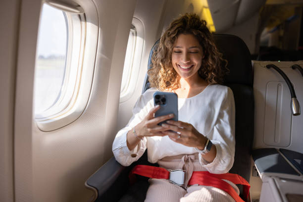 istock Happy woman using her cell phone in an airplane 1691534172