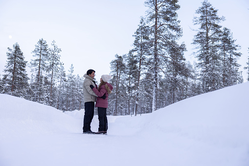 Loving couple enjoying the winter outdoors in Finland in a romantic getaway