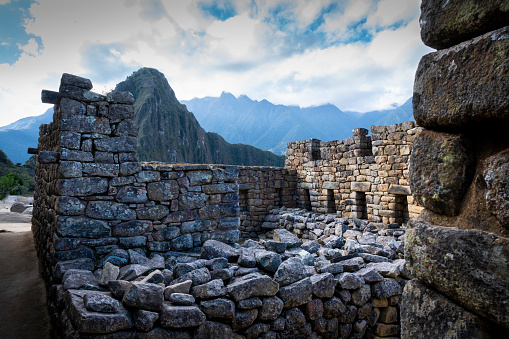 A panoramic view of Machu Picchu, the ancient lost city of the Inca's. This historic archaeological site is surrounded by Terraced gardens and dense rain Forrest in the Andes Mountains, 2430m above sea level in Peru. The buildings and walls are made from rocks perfectly fitted together by the Inca's.