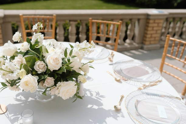 White roses adorn table at elegant wedding reception.