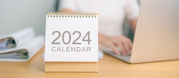 istock 2024 Year Calendar on table with business woman using laptop computer. countdown, Happy New Year, Resolution, Goals, Plan,  Action, Mission and financial Concept 1691709457