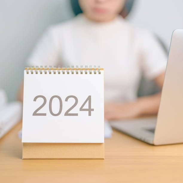 istock 2024 Year Calendar on table with business woman using laptop computer. countdown, Happy New Year, Resolution, Goals, Plan,  Action, Mission and financial Concept 1691709460