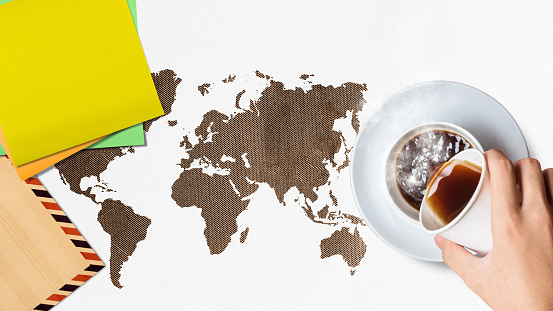 A human hand is pouring a coffee with the empty paper. International coffee day concept