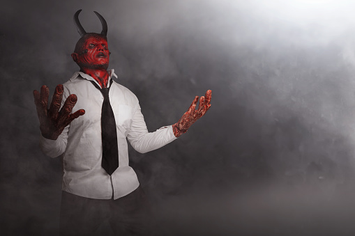 Devilman is standing in the dark background. Scary demon Halloween concept
