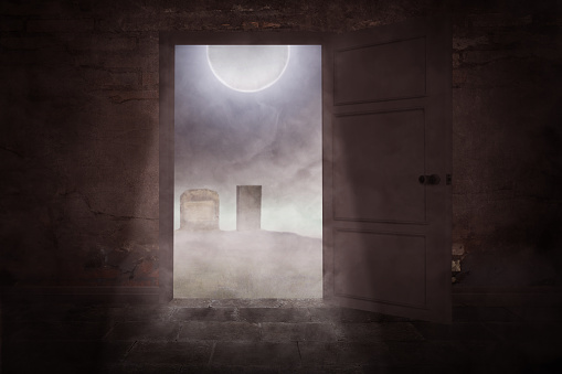 Opened the door with a view of tombstones in the graveyard with full moon background. Scary Halloween background concept