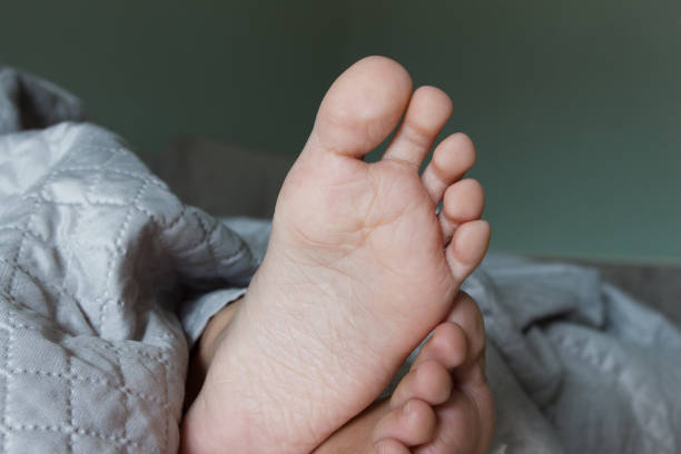 istock Feet under a light blanket on the bed, soft focus background 1691736324