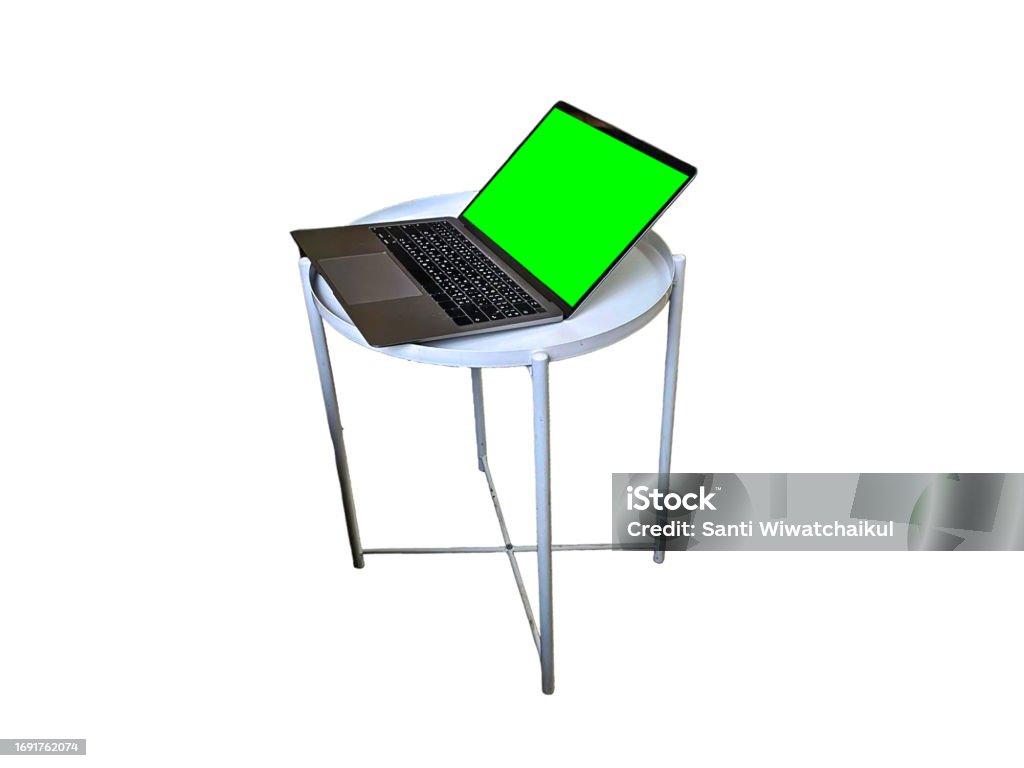 Laptop with green screen on white round table. Isolated on white background. Black Color Stock Photo