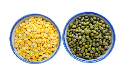 Peeled split mung bean in a bowl, green mung bean seeds in a bowl on white background with clipping path.Top view
