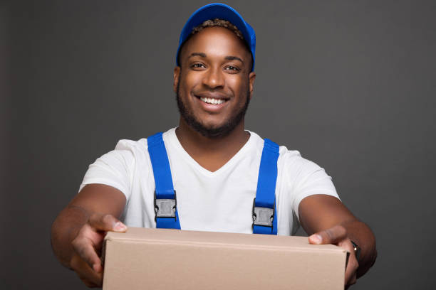 istock Longshoreman in baseball cap holds forward empty box transfers for packing goods 1691780437