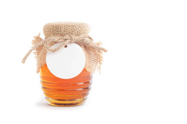 istock Honey in a jar and blank white product label on a white background. 1691790513