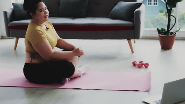 large build woman doing yoga exercise at home