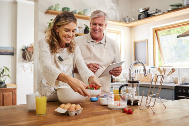 istock Tablet, cooking and internet with a senior couple baking using a recipe in the kitchen of their retirement home. Food, technology and love with an elderly man and woman pensioner preparing a meal 1691812361