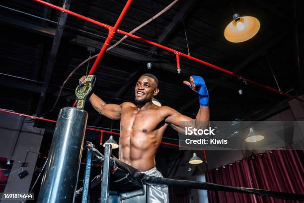African Muscular Boxer Raises His Arms After Win Tournament On Stage Attractive Male Athlete Fighters Shirtless Feel Happy And Excited Enjoy Boxing Exercise In The Ring At Stadium On Competition Stock Photo - Download Image Now