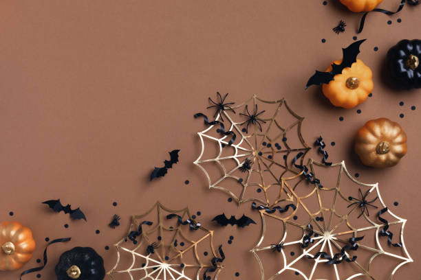 istock Halloween holiday background with party decorations from pumpkins, bats, spider web and ghosts with confetti and ribbon top view. Happy halloween greeting card flat lay. 1691815196