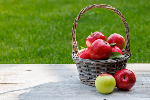 3 Different kinds of apples and the tasty benefits of each.\ncolorful and various kinds of apples in the basket on wooden background.