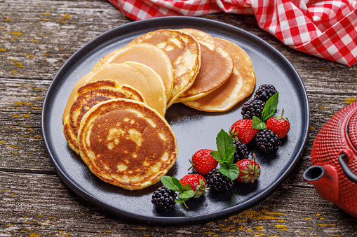 Tasty homemade pancakes with berries and tea