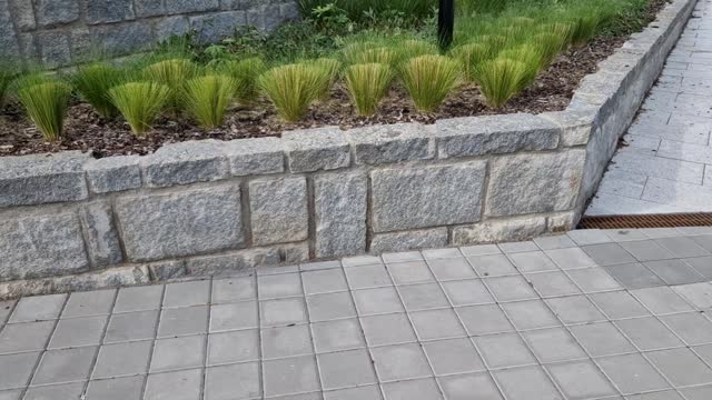 Granite walls made of stone blocks serve as design elements, retaining walls, or seating areas, seats for park visitors. parking for bicycles with metal frames and benches made of horizontal wires