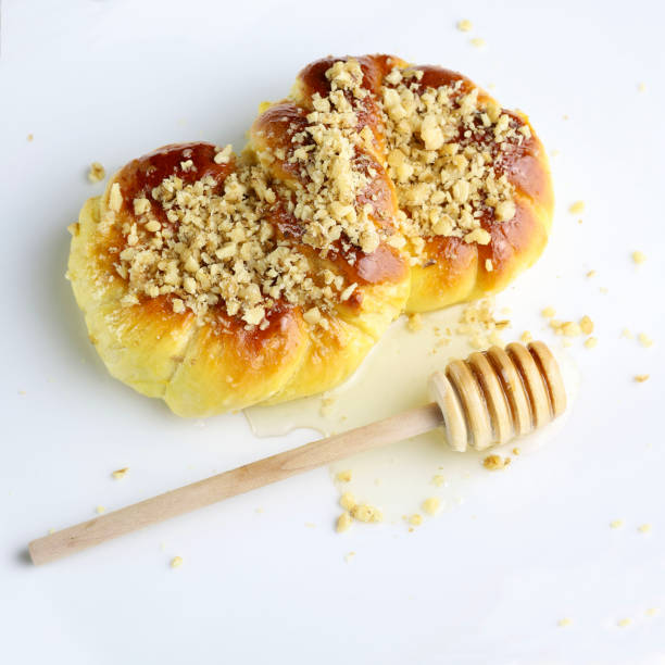 Homemade Mucenici, traditional desserts made in the figure 8 to look like garlands, smeared with honey and chopped nuts isolated on white background. Concept of romanian cuisine. Overhead view.