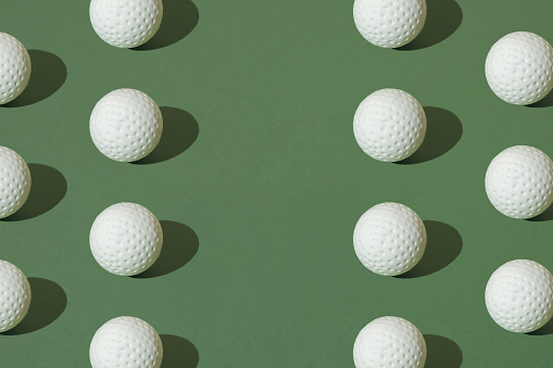 White golf ball on a green pastel background. Minimal pattern with copy space.