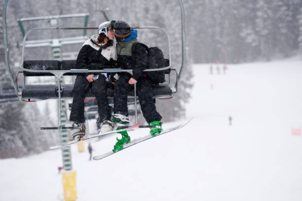 istock Snowboard couple kiss while riding chairlift 169186026