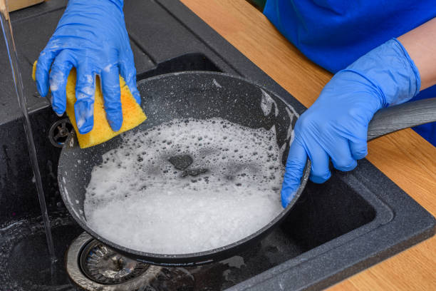 istock Scrubbing a dirty and greasy pan in the sink 1691860520