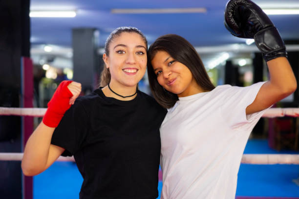 Two female boxers portrait in a boxing ring.