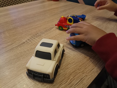Young children playing with toy cars on a table