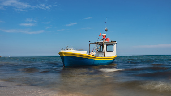 Fishing boat on the beach in Sopot, Poland. Magnificent long exposure calm Baltic Sea. Wallpaper defocused waves. Fishermans sea bay Vacation and holidays. travel attraction tourist destination
