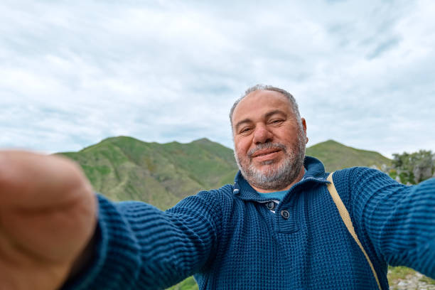 istock Middle aged bearded man using smartphone to take selfie during the trekking in mountain. Mental health, wellbeing, trip adventure and healthy lifestyle. 1691888878