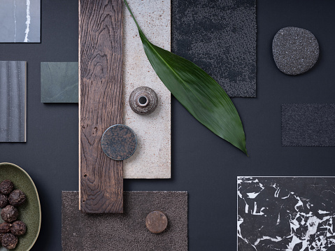 Aesthetic  flat lay composition in grey and navy color palette with textile and paint samples, lamella panels, leaves and tiles. Architect and interior designer moodboard. Top view. Copy space.