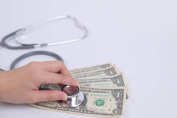 istock close up young hand hold stethoscope and place on dollar bill. financial problems, financial problems concept. Healthy Financial and Insurance Concept. Healthcare cost concept. 1691898666