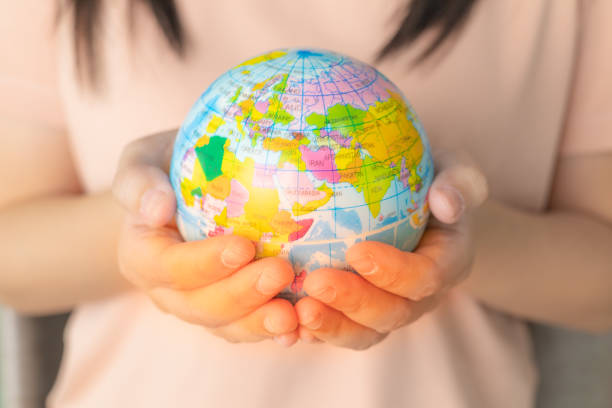 istock Woman's hand holding a globe with light coming out. World environment and earth day. save the world concept. Environment save, taking care of nature and ecology, Globe worldwide protection. 1691899847