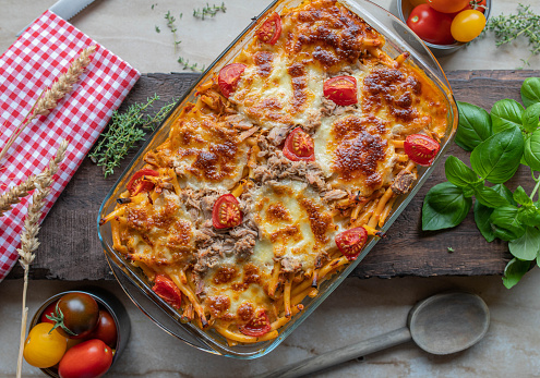 Delicious casserole or bake with canned tuna in a creamy tomato sauce with macaroni noodles. Topped with cherry tomatoes and mozzarella cheese. Top view