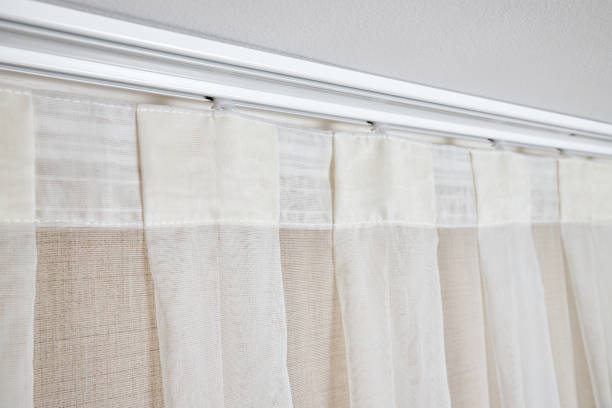 istock Ceiling cornice with drapes and white curtain or tulle. Interior details close up. White ceiling, plastic ceiling cornice with two rails and transparent curtains. 1691916238