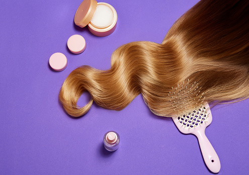 Shiny, healthy, glowing blonde hair on purple background. Professional hair treatment with mask and conditioner. Concept of hair care, organic products, natural beauty, cosmetics. Ad. Poster.