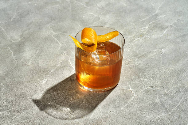 istock Old fashioned cocktail with whiskey and orange on a wooden table. Hard light. Alcoholic cocktail menu 1691928865